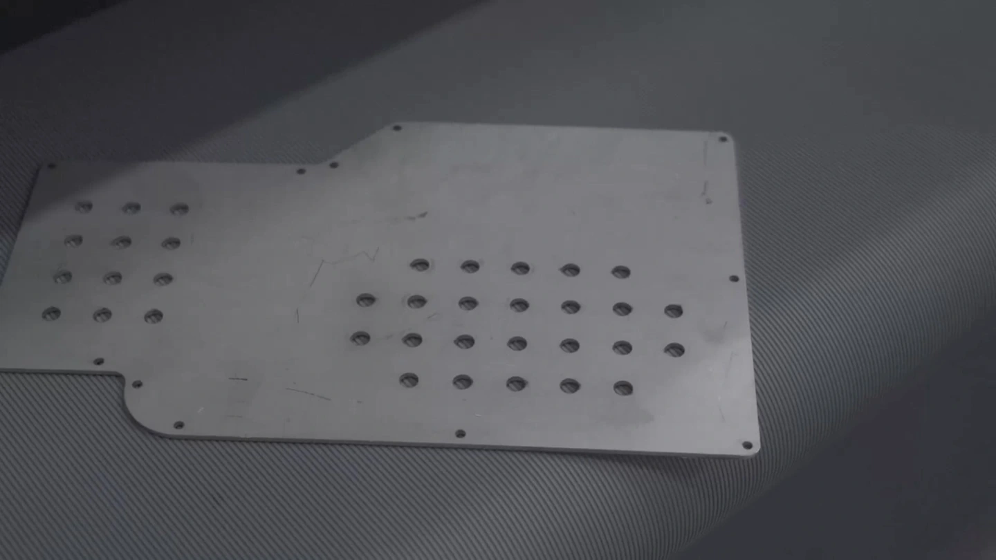 Înainte de prelucrare: piesă debitată laser, cu două zone perforate și muchii neprelucrate